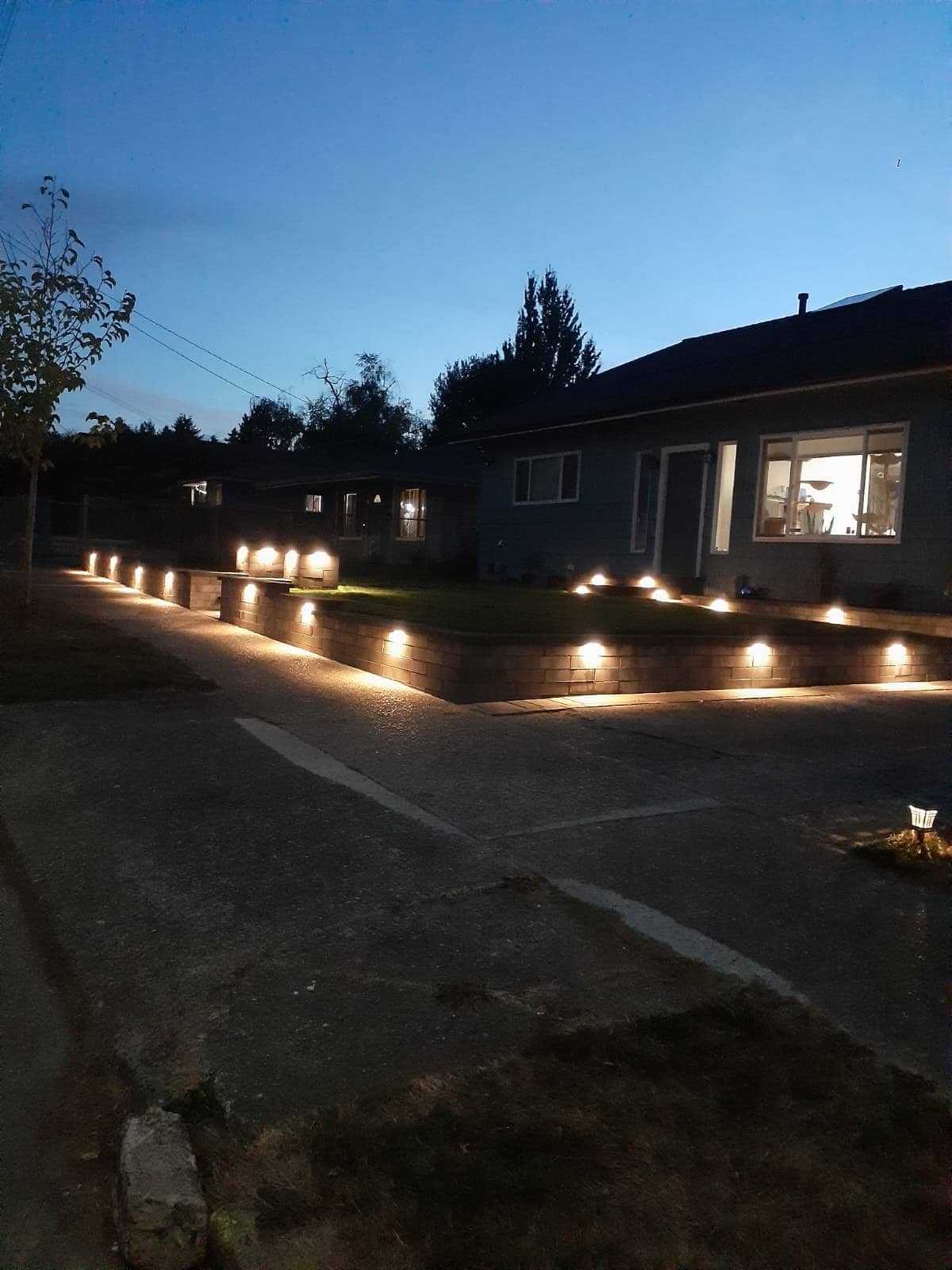 Front retaining wall at night with built-in cap lights